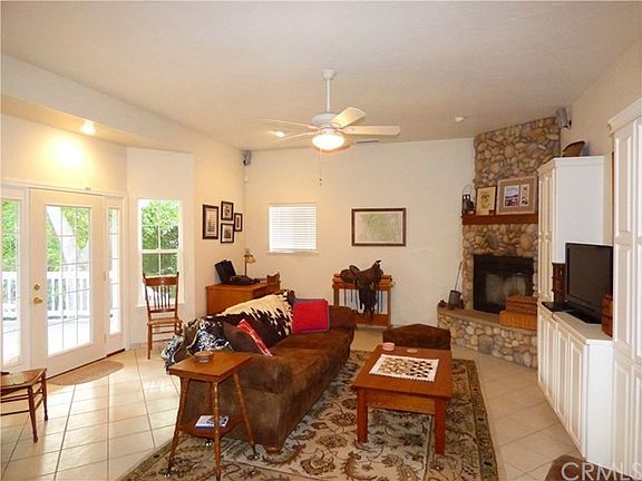 Family Room with Tile Flooring, Stone Fireplace, and Doors to Deck
