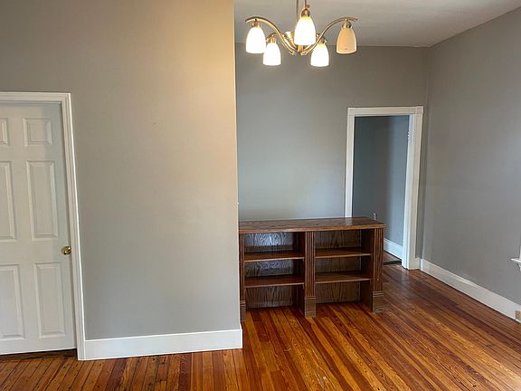 Stairs leading downstairs are behind built-in shelves.