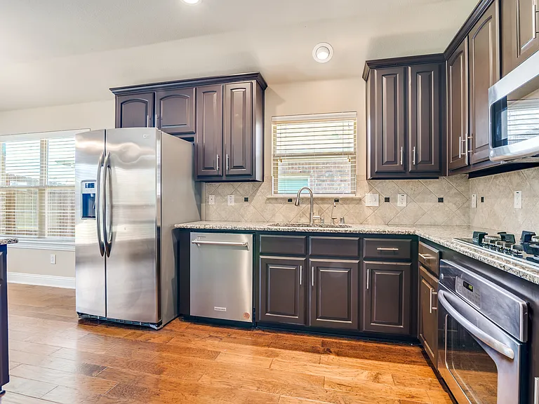 Kitchen with gas cooktop, oven, microwave, dishwasher & refrigerator included.