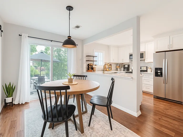 Enjoy intimate meals in this charming dining nook, where natural light pours in through the sliding glass doors
