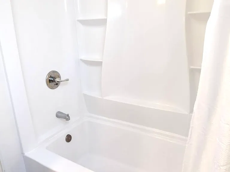 Main bathroom tub and shower with surround.
