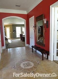 Front hall with decorative tile insert and wall sconces