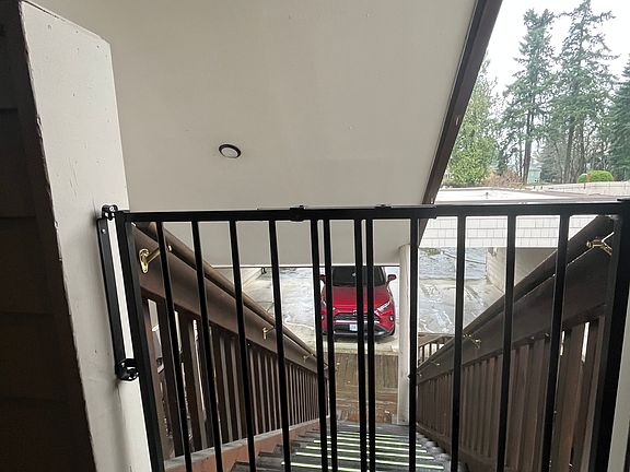 Stairs down to carport with dog/toddler safety gate closed.