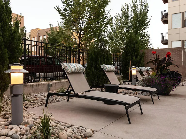 Outdoor Pool Deck with Padded Chaise Lounges and Accent Lighting
