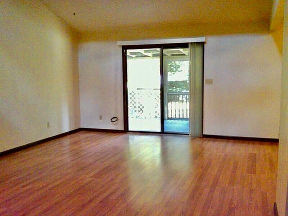 Living room/dining room area with vaulted ceiling - view of back screened porch and back yard
