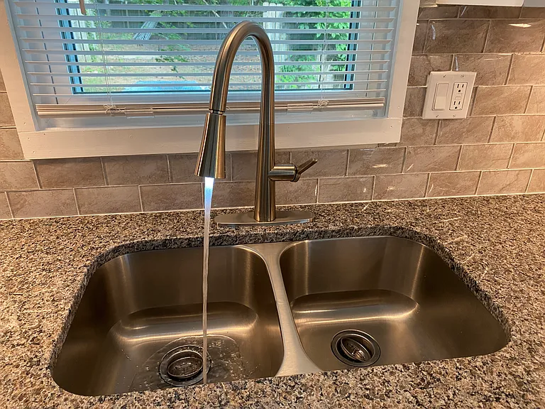 Deep stainless steel sink with LED water stream.
Backsplash is glass tile
Plenty of wall outlets for appliances