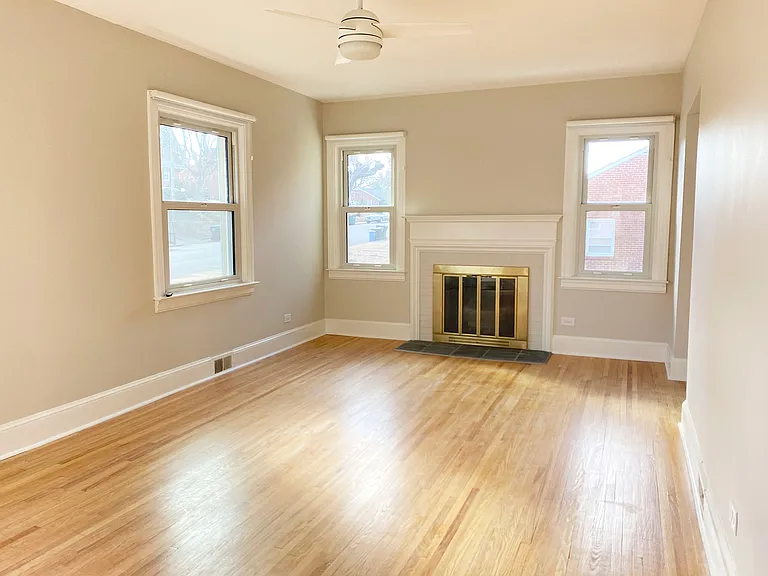 Living room with hardwood floors, a fireplace with slate tile threshold and plenty of light. Note: fireplace is non-working.
