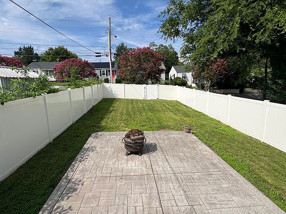 Large backyard with concrete patio and privacy fence.