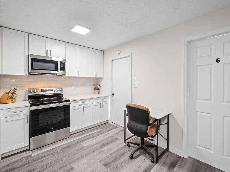 Updated kitchen with shaker cabinetry, subway-tile backsplash, and stainless range with over-the-range microwave.