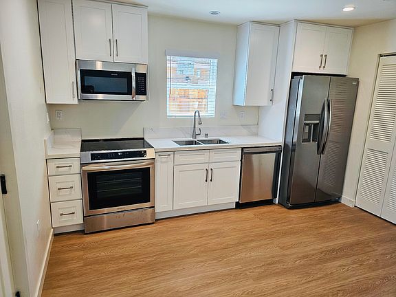 Kitchen with new stainless-steel appliances, and laundry area with a brand-new washer and dryer.