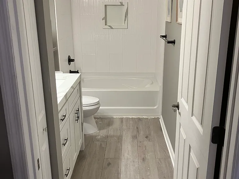 Renovated bathroom with quartz countertops, and floor to ceiling tile in shower/tub combo.