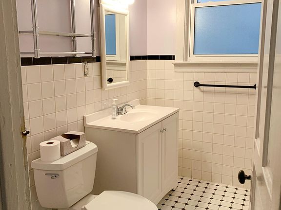 Bathroom with storage closet, bath tub with shower.