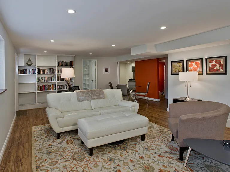 Living room view toward bookshelves, dining area