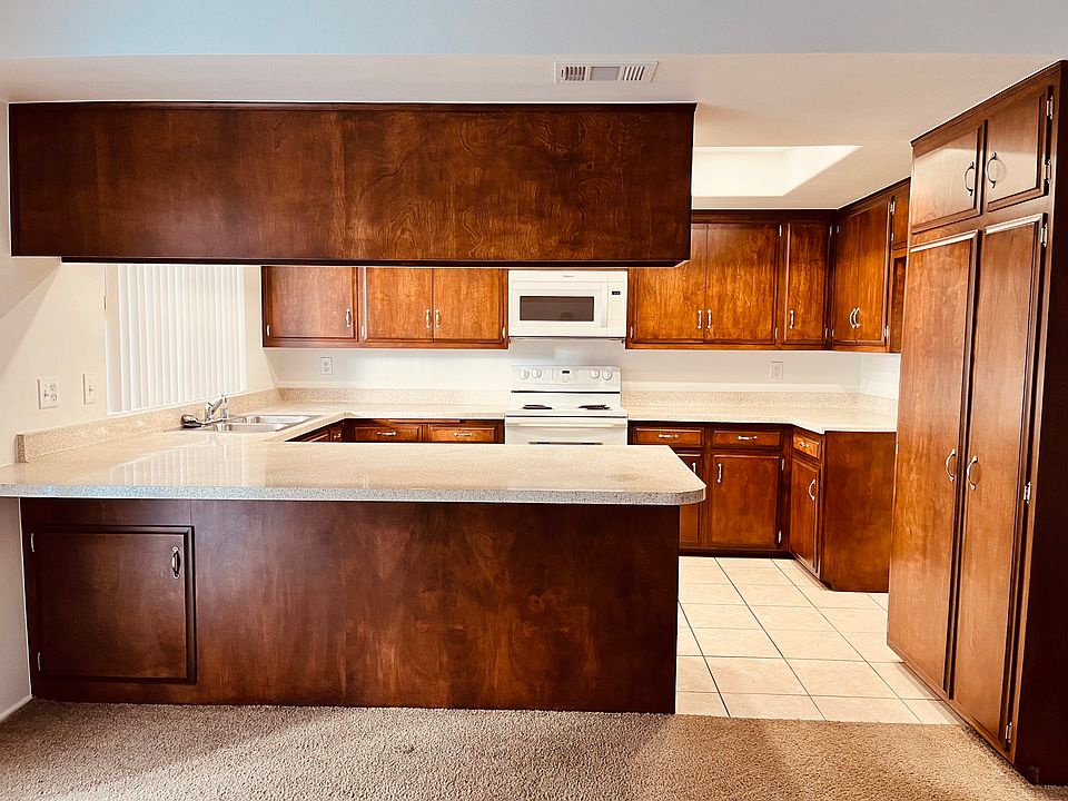 Kitchen with ample cabinets, electric stove, microwave, dishwasher, and garbage disposal.