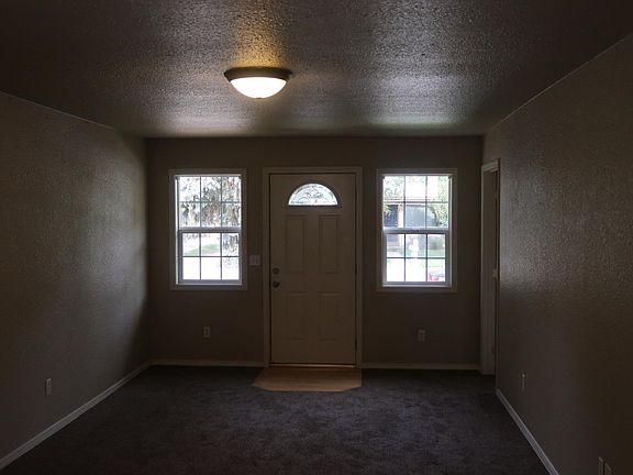 standing in dining area looking back to main room and front doors. We've since added blinds to those windows (and rest of windows in house too!)