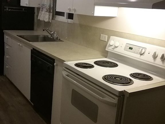 Electric stove/oven, dishwasher, lots of cabinets on both sides of "galley" kitchen..