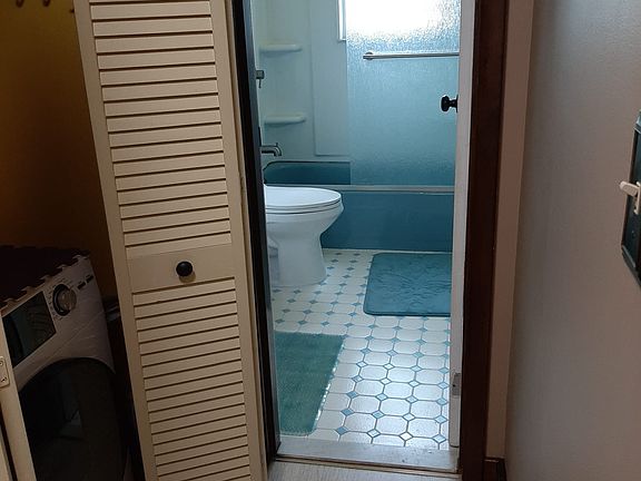 Closet with washer/dryer in passage to bathroom