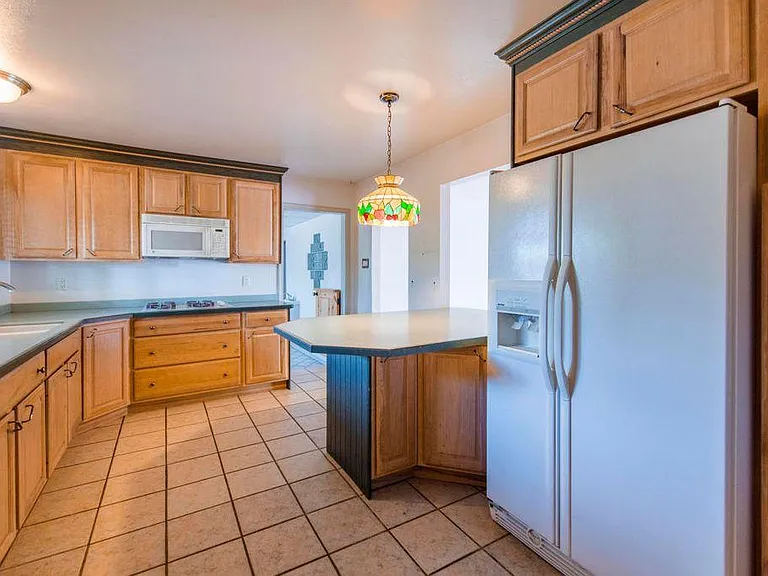 Kitchen with large 2 door fridge and water and ice in the do