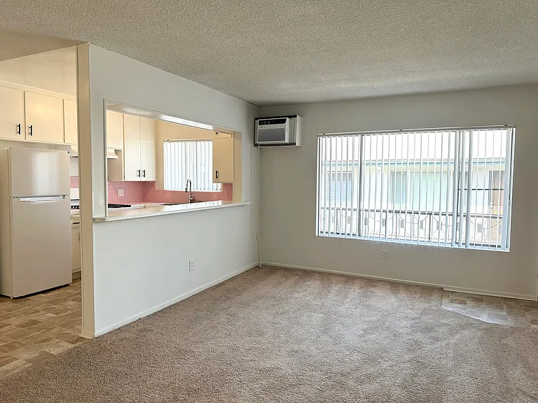 Livingroom with large windows and AC Unit.