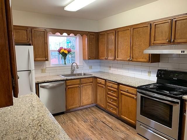 Kitchen with new Granite Counter, Subway Tile Backsplash, New Appliances and Flooring.