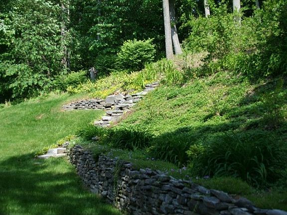 Beautiful stone wall and pathway leading to wooded area