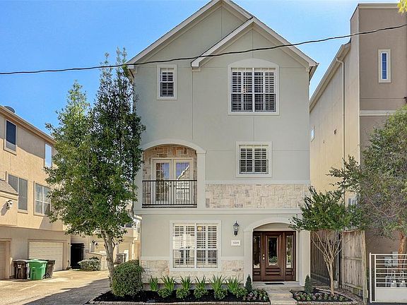 The home faces north and has hardi-plank siding on the west and south sides and stucco and stone on the front elevation and east side. Crape myrtle and holly trees frame the home and accent gardens in front.