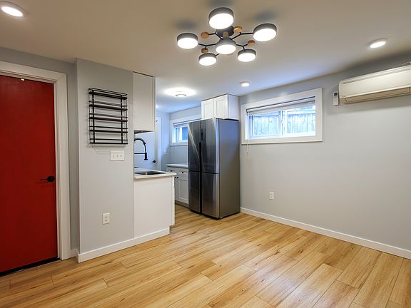 Living space, red bathroom door, full kitchen