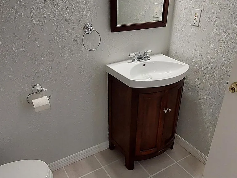 Hall bathroom with storage in vanity, and cabinet above the toilet.