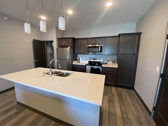 Large island in kitchen, lots of cabinet space, dishwasher, large pantry, and washer dryer to double doors on right.