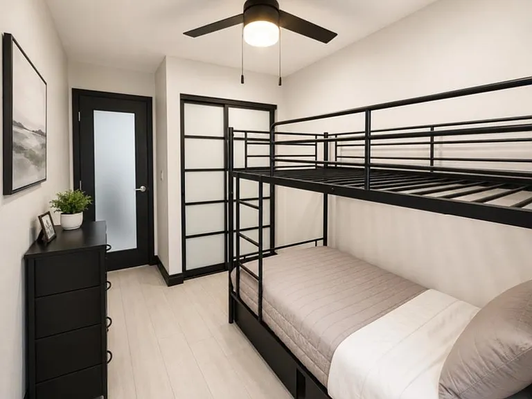 Bedroom with bunk bed, dresser storage, ceiling fan, and modern black-trim doors for added privacy.