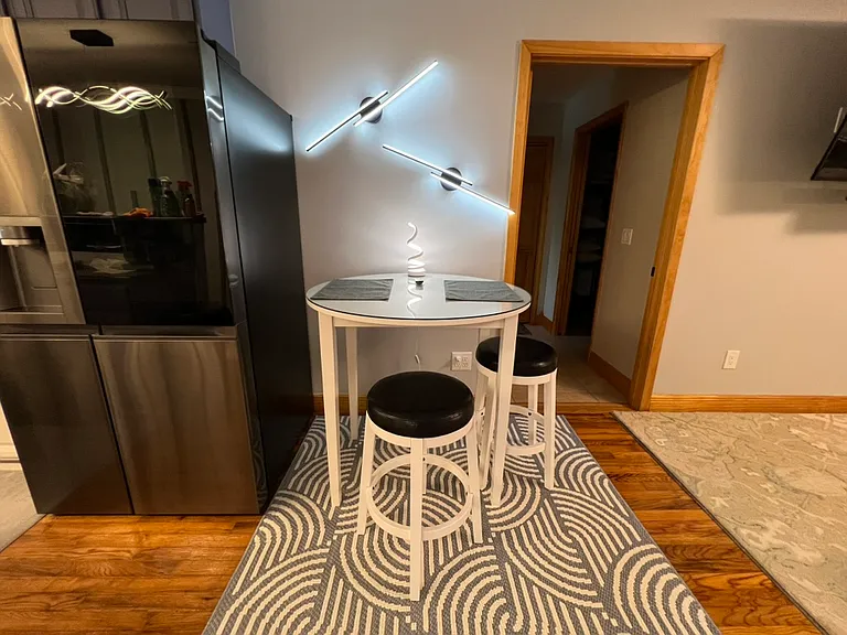 Dining table with 2 stools. Modern lighting. Art deco carpet.