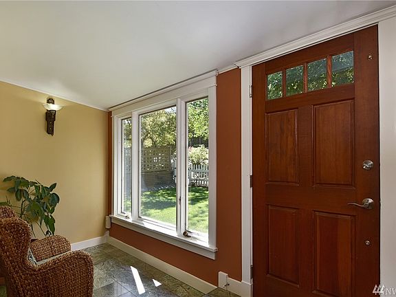 This enclosed picture window mudroom makes for a serene setting and ideal spot to shed the outdoors.