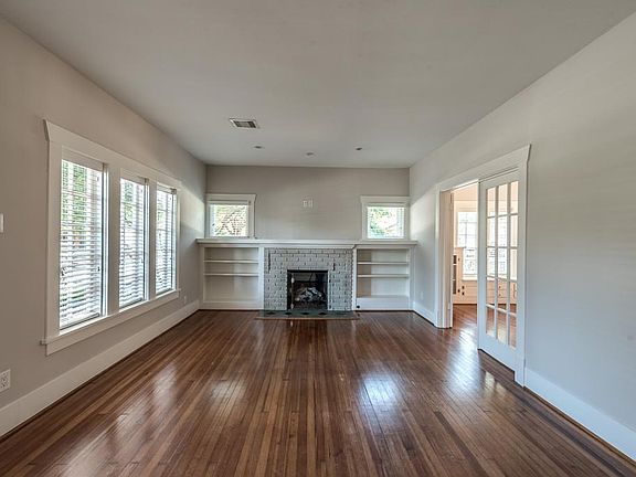 Spacious living room with gas fireplace and bookshelves flanking each side.