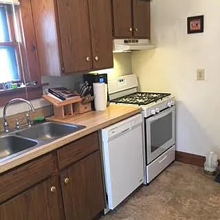 Kitchen with new gas range, dishwasher, and flooring.