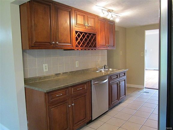 This view shows the miles of counterspace in this Kitchen and the stainless steel dishwasher next to the new double sink. The cabinetry is cherry-stained maple w/a ceramic tile backsplash and flooring.