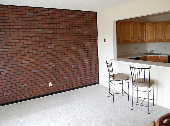 Living/dining room features faux red brick wall.