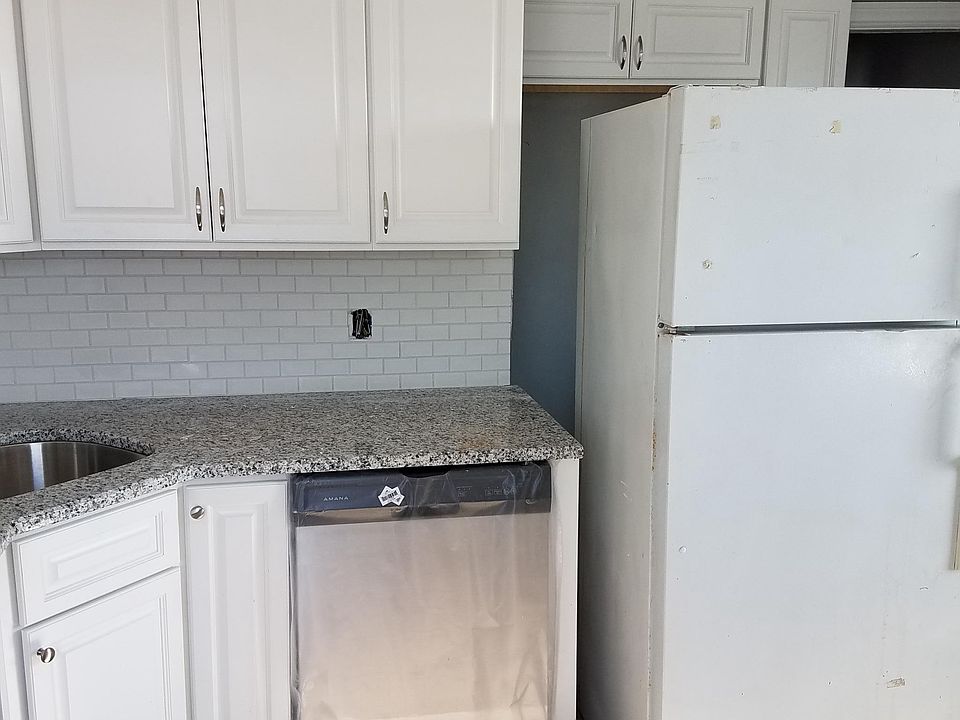 Kitchen showing stainless steel dishwasher and corner sink