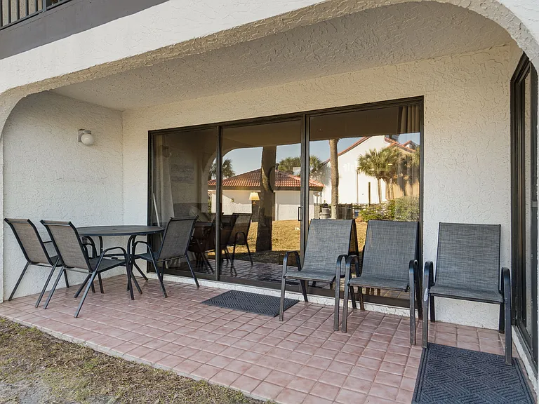 Just outside the King Master Bedroom is a patio with multiple chairs and a table.