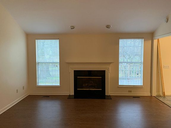 Living room with gas logs, cathedral ceiling, and ceiling fan.