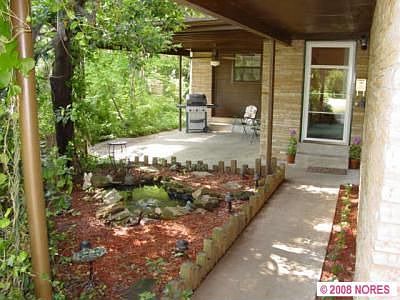 Front walkway with secluded porch and pond.
