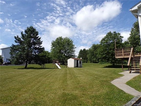 lovely back yard with concrete path to back deck
