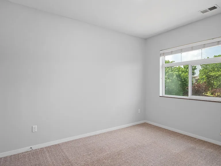 Bright and spacious room with plush carpet, large window offering a beautiful view, and a blank canvas ready for personal touch. Bright and spacious room with plush carpet, large window offering a beautiful view, and a blank canvas ready for personal touc