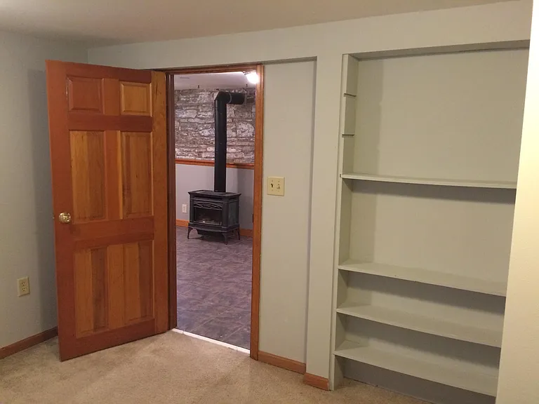 Bedroom with shelves (closet to right).