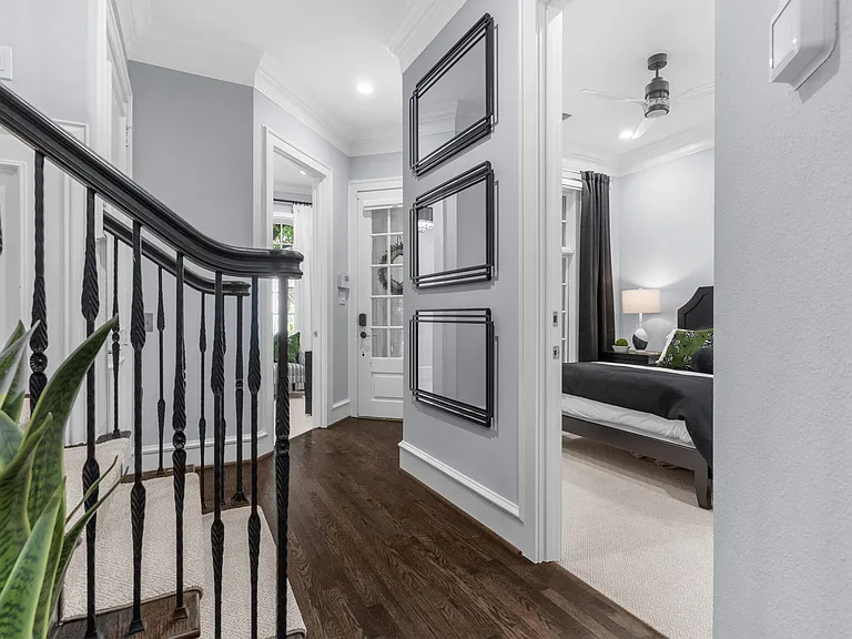 Elegant entrance hallway with a modern staircase leading to the upper floors and the first bedroom to the right.