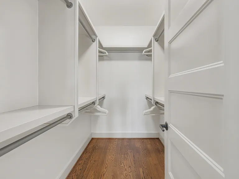 King sized bed in bedroom 2, featuring a walk-in closet, dresser, smart TV, full-length mirror, and ensuite bathroom.