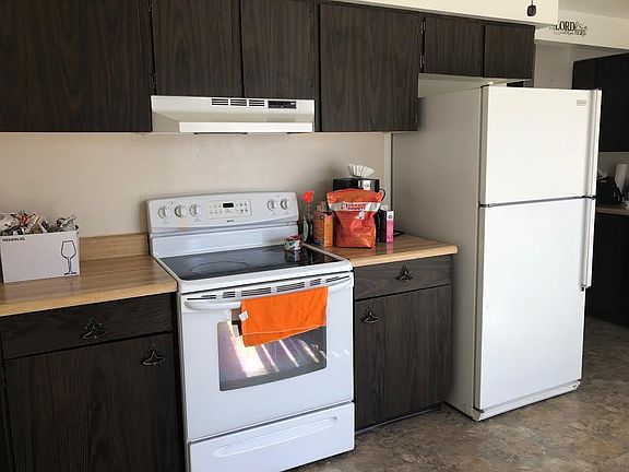 More kitchen with stove and refrigerator