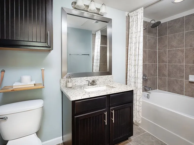 Bath with espresso cabinetry, granite countertop, and tile flooring