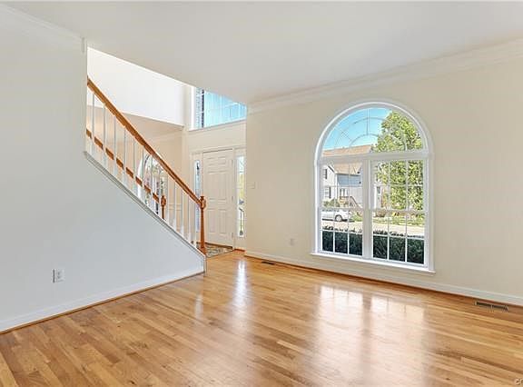 Formal living room with hardwood floors, crown molding, and beautiful window!