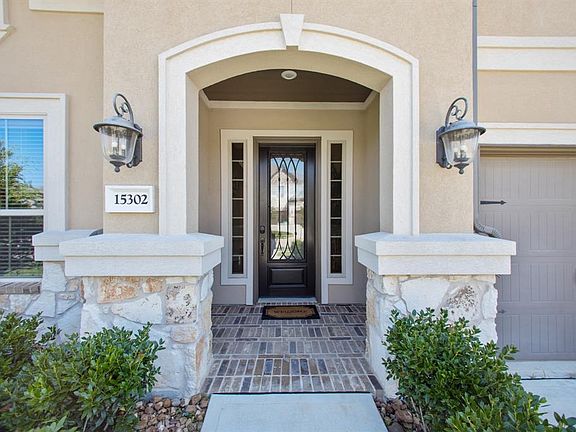 Beautiful grand entry with stone columns, brick floor and glass door