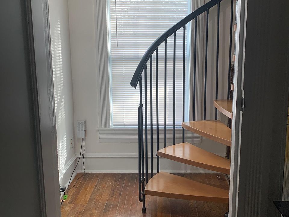 Entrance into apartment, stairs up to living area, laundry room on the right